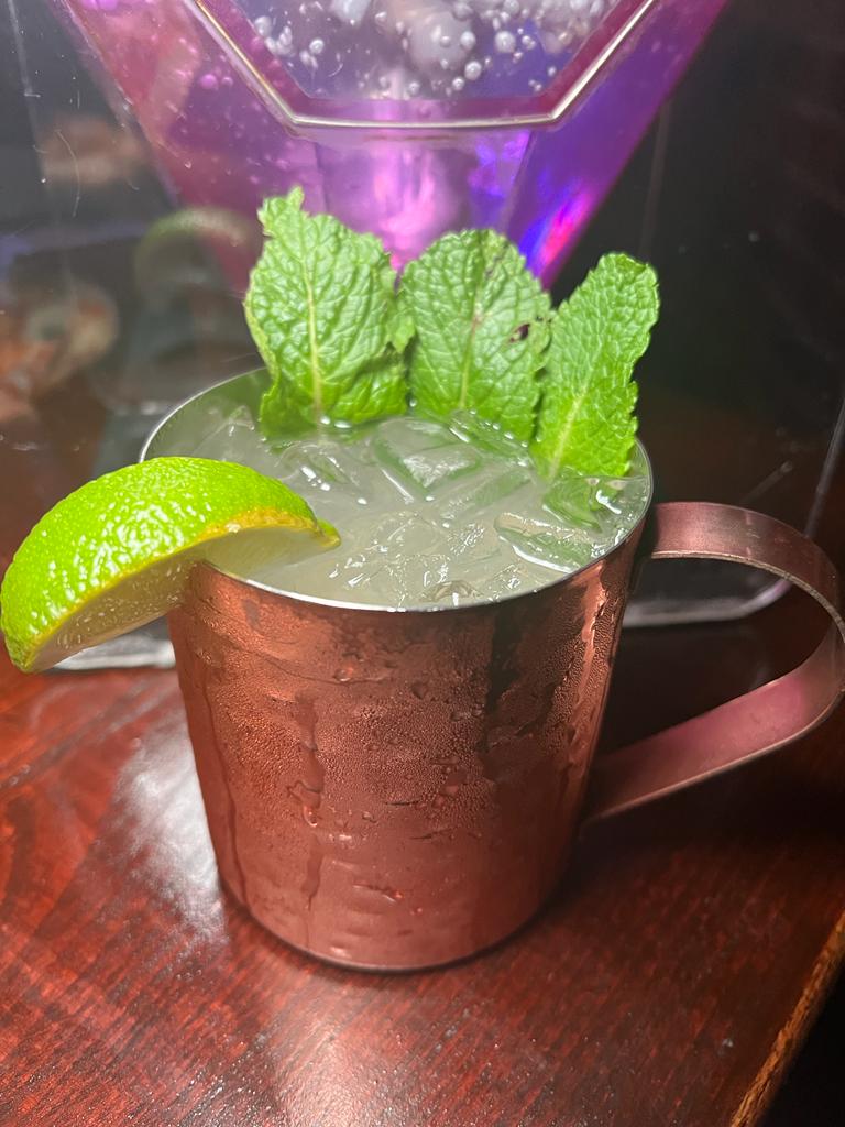 A refreshing Moscow Mule served in a copper mug, garnished with fresh mint leaves and a lime wedge.